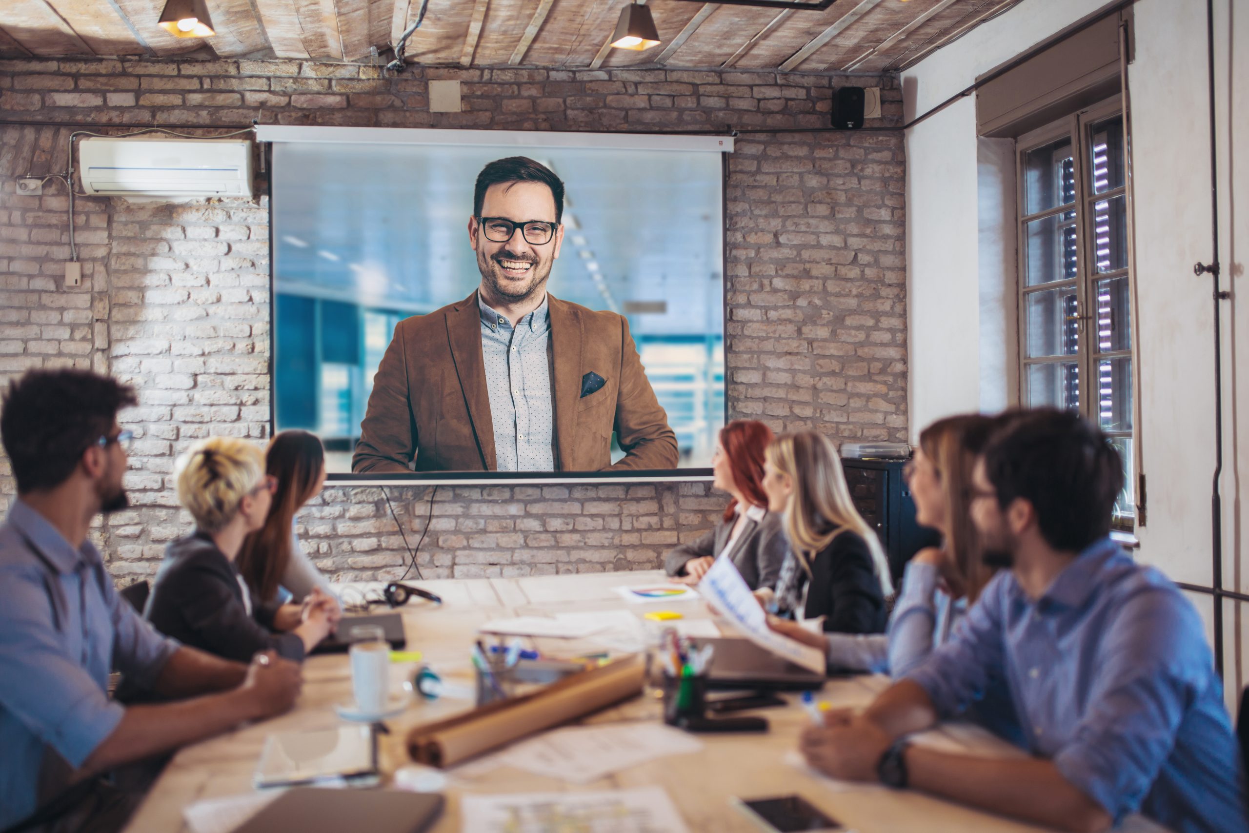 Business people looking at projector during video conference in office